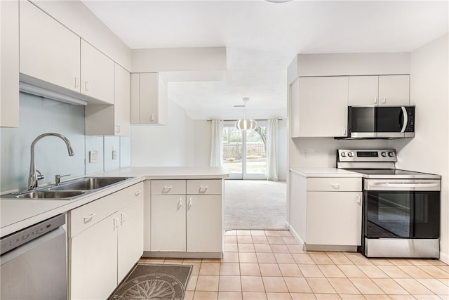 kitchen featuring a sink, white cabinetry, stainless steel appliances, a peninsula, and light countertops