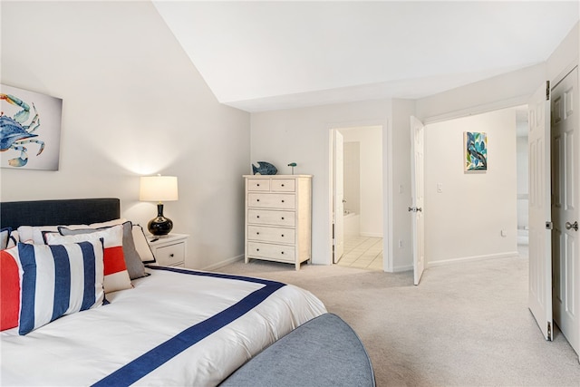 bedroom featuring baseboards, light carpet, and ensuite bath