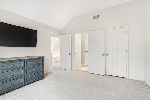 bedroom featuring lofted ceiling, baseboards, visible vents, and light carpet