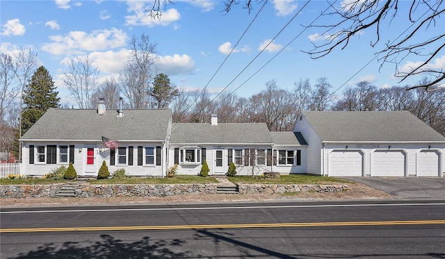 view of front of home featuring a garage, driveway, and a shingled roof