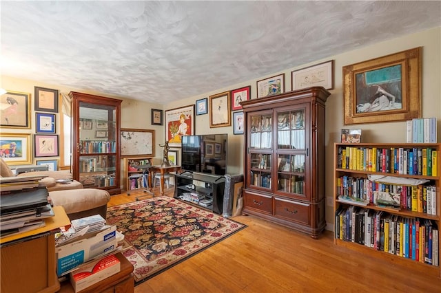 interior space with a textured ceiling and wood finished floors