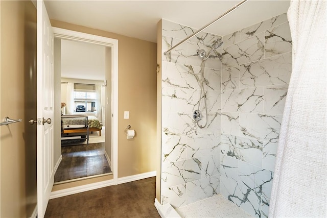 full bathroom featuring connected bathroom, a marble finish shower, baseboards, and wood finished floors