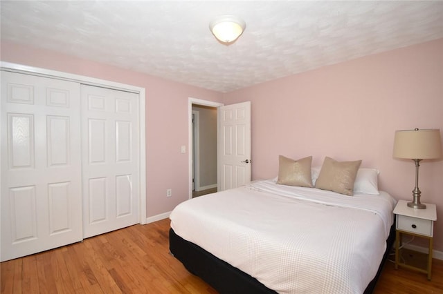 bedroom featuring a closet, baseboards, and wood finished floors