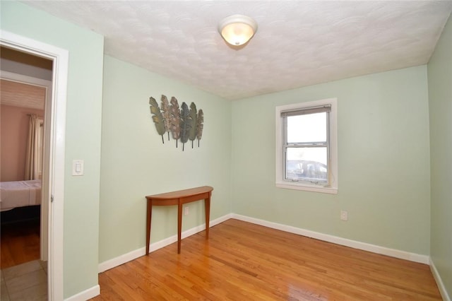 spare room with light wood-style flooring and baseboards