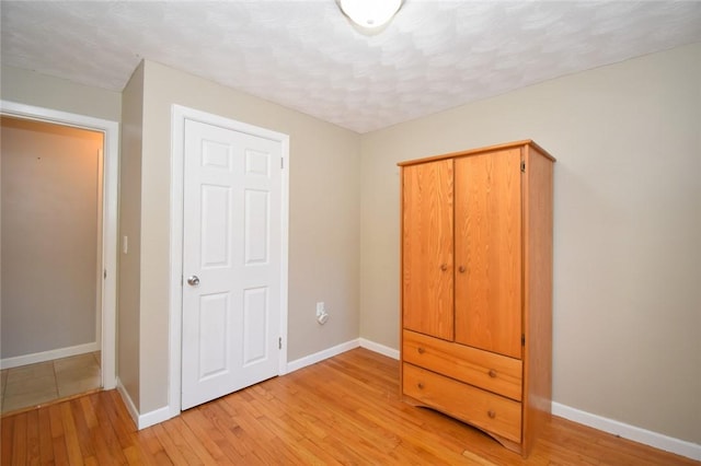 unfurnished bedroom with light wood-type flooring and baseboards