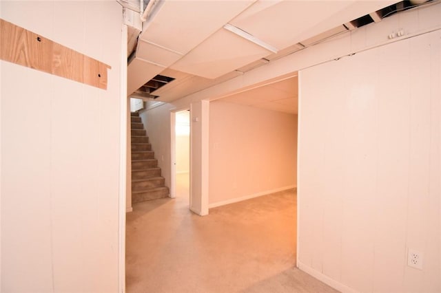 finished basement featuring stairs, carpet floors, and a paneled ceiling