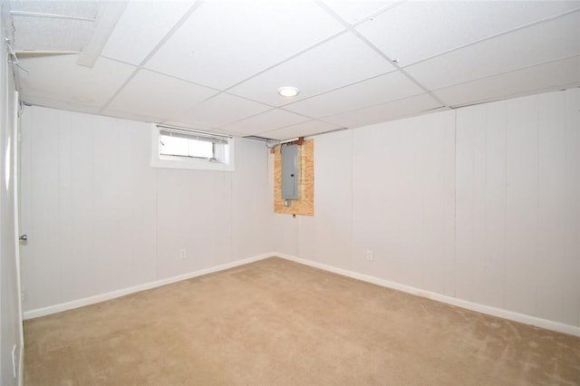 basement with carpet floors, electric panel, a drop ceiling, and baseboards