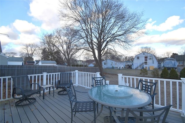 deck with a fenced backyard, a residential view, and outdoor dining area