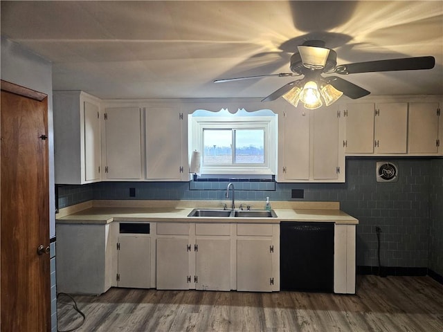 kitchen with a sink, white cabinets, dishwasher, and wood finished floors