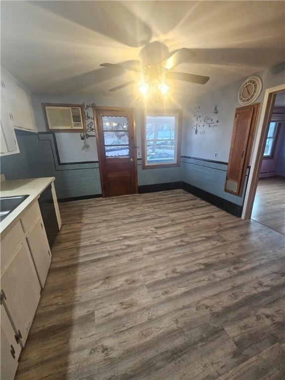 kitchen featuring a wall mounted AC, wainscoting, dark wood finished floors, and a wealth of natural light