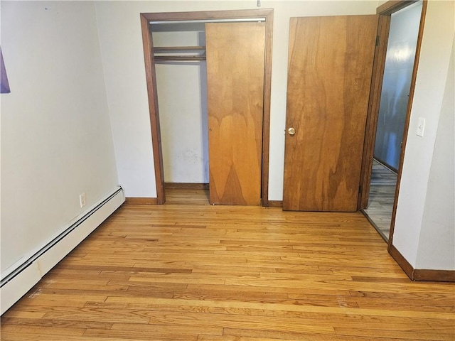 unfurnished bedroom with baseboards, light wood finished floors, and baseboard heating