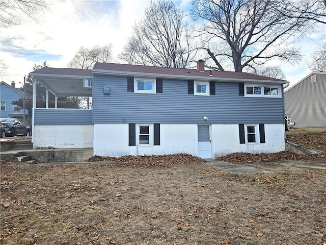 view of front of property featuring a sunroom and a chimney