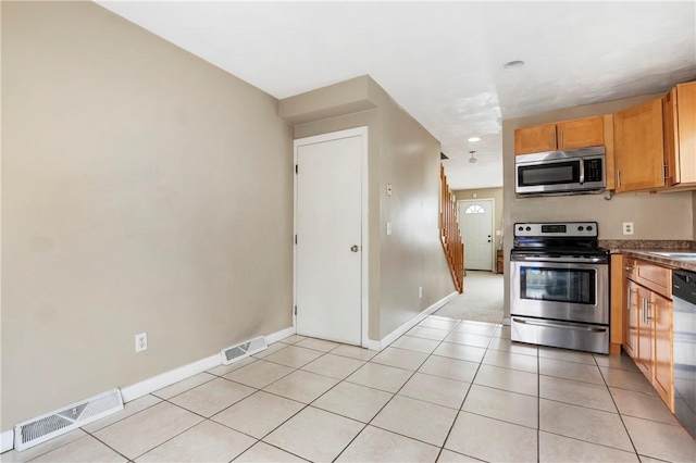 kitchen featuring baseboards, visible vents, stainless steel appliances, and light tile patterned flooring