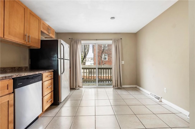 kitchen with visible vents, baseboards, brown cabinetry, dishwasher, and light tile patterned flooring