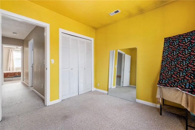 bedroom featuring a closet, baseboards, visible vents, and carpet flooring