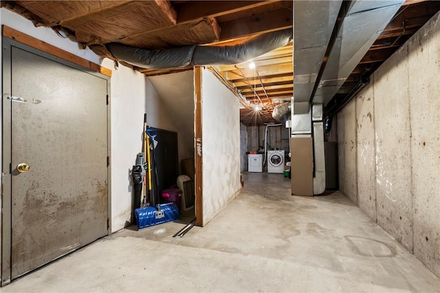 unfinished basement with washer and clothes dryer and heating unit