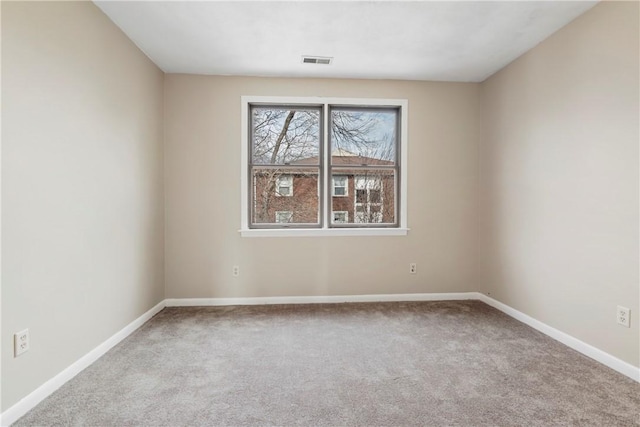 carpeted spare room with visible vents and baseboards