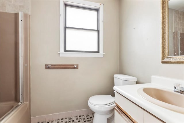 full bathroom featuring toilet, bath / shower combo with glass door, vanity, and baseboards