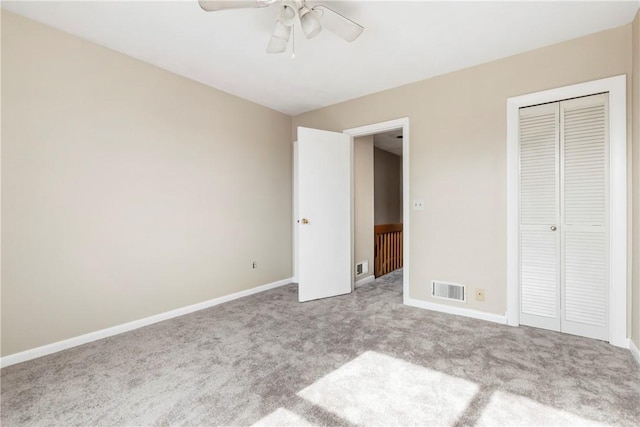 unfurnished bedroom featuring carpet floors, baseboards, visible vents, and a closet