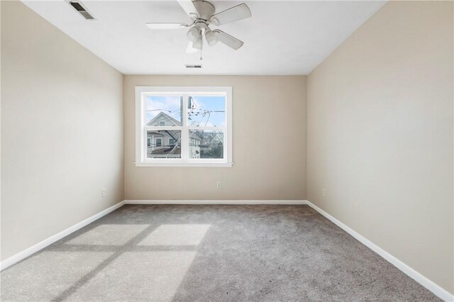 unfurnished room featuring carpet floors, baseboards, visible vents, and a ceiling fan