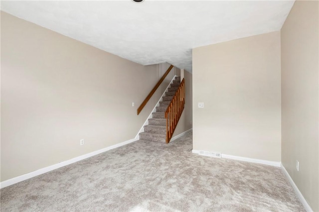 carpeted empty room with visible vents, stairway, and baseboards