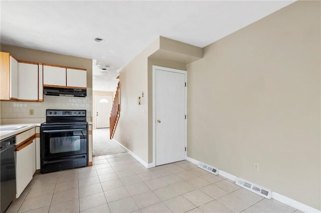 kitchen with light countertops, visible vents, backsplash, under cabinet range hood, and black appliances