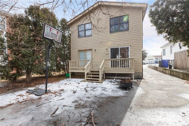 back of house featuring an outdoor fire pit and a deck