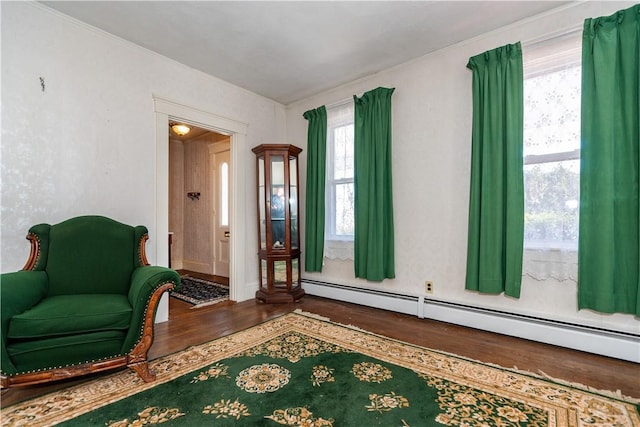 living area with a baseboard heating unit and wood finished floors