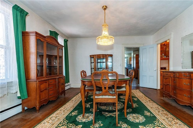 dining space with a baseboard heating unit, dark wood-style flooring, and a notable chandelier