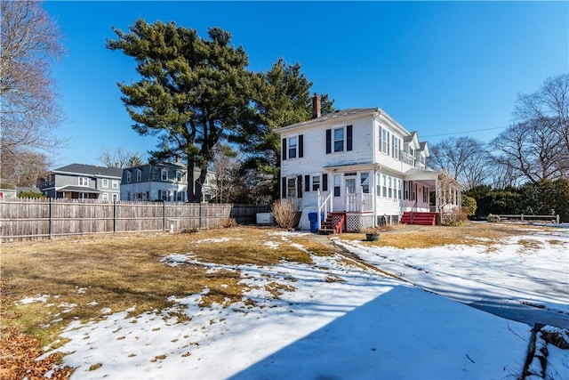 exterior space featuring a sunroom, a chimney, and fence