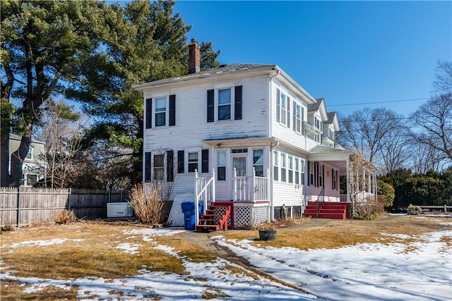 view of front of house with a chimney and fence