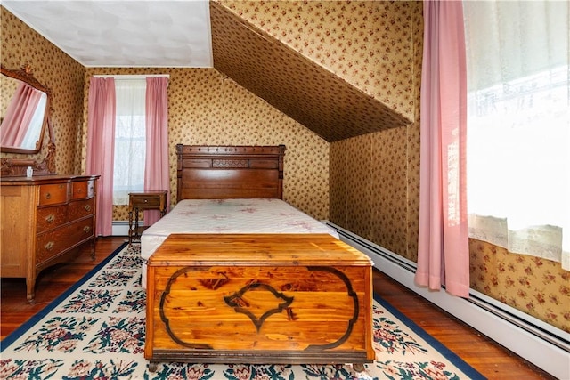 bedroom with lofted ceiling, a baseboard radiator, wood finished floors, baseboard heating, and wallpapered walls