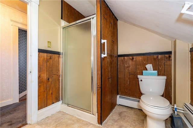 full bathroom featuring a stall shower, toilet, a wainscoted wall, tile patterned flooring, and a baseboard heating unit