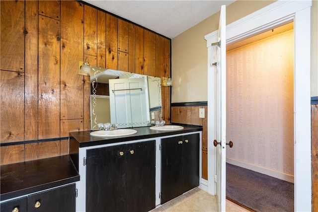 kitchen with dark countertops, dark cabinetry, and a sink