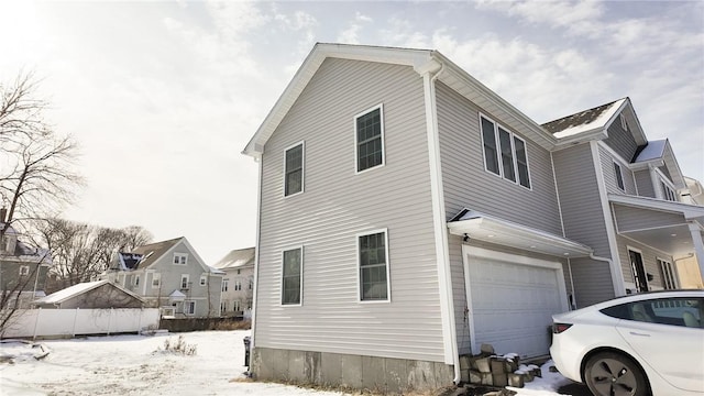 view of snow covered exterior featuring a garage