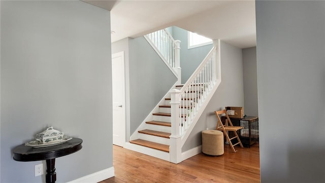 stairway featuring hardwood / wood-style flooring and baseboards