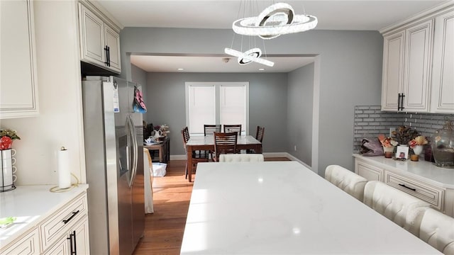 kitchen featuring light wood-style floors, light countertops, stainless steel fridge, and baseboards