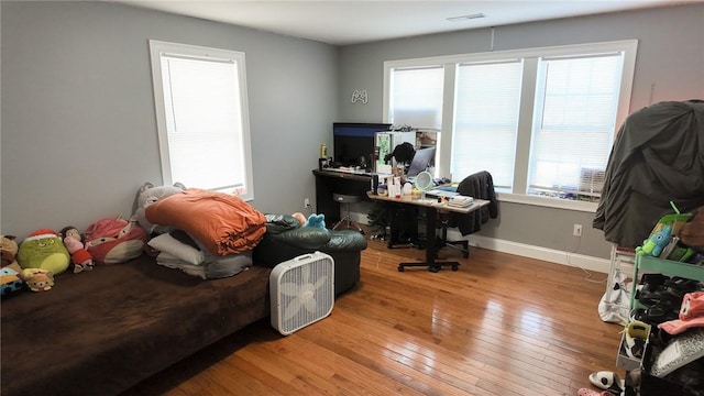 office with hardwood / wood-style flooring, baseboards, and visible vents