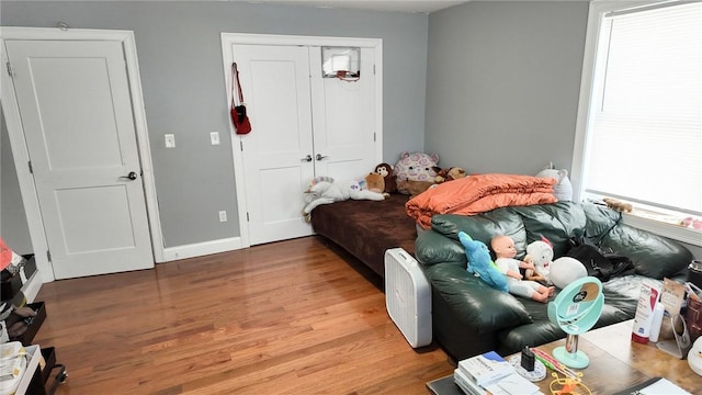 bedroom with a closet, baseboards, and wood finished floors