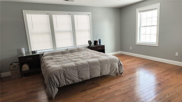 bedroom featuring visible vents, baseboards, and hardwood / wood-style flooring