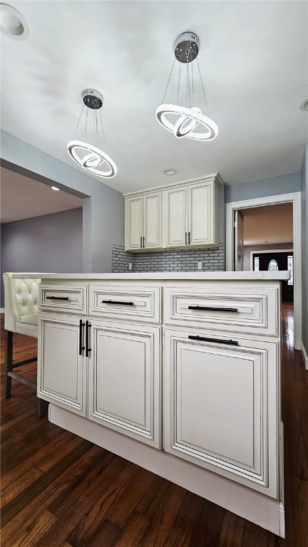 51 Spring St, Pawtucket, RI 02860 - kitchen featuring dark wood-style flooring, tasteful backsplash, hanging light fixtures, and light countertops