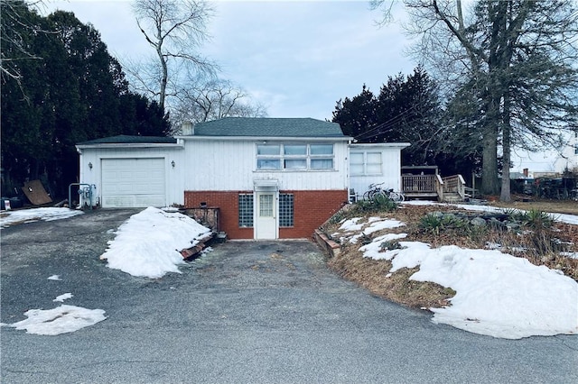 view of front of home with a garage, brick siding, and driveway