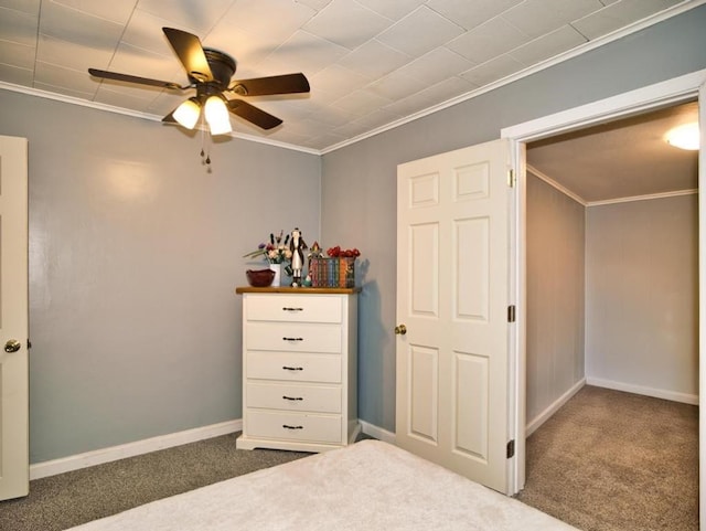 unfurnished bedroom with baseboards, ornamental molding, carpet, and a ceiling fan