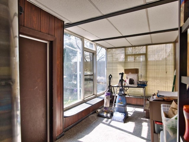 workout area featuring wood walls and a paneled ceiling