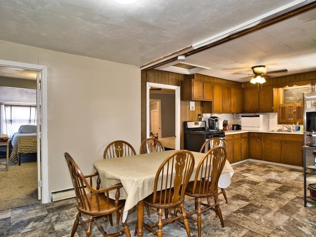 dining room with stone finish flooring, ceiling fan, and baseboard heating