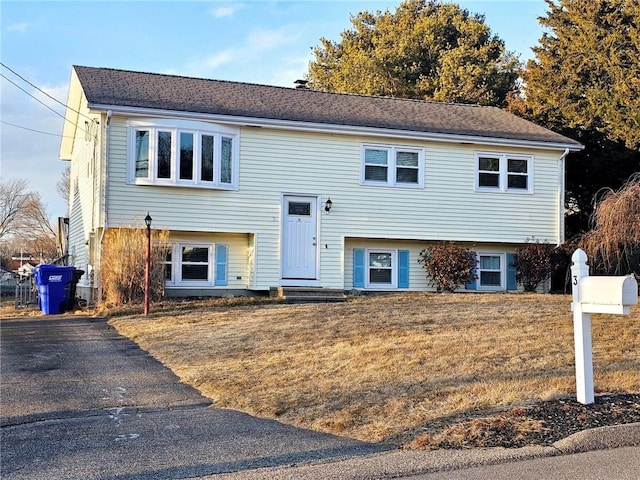 raised ranch featuring a front yard and entry steps