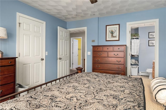 bedroom with a baseboard radiator, connected bathroom, and ceiling fan