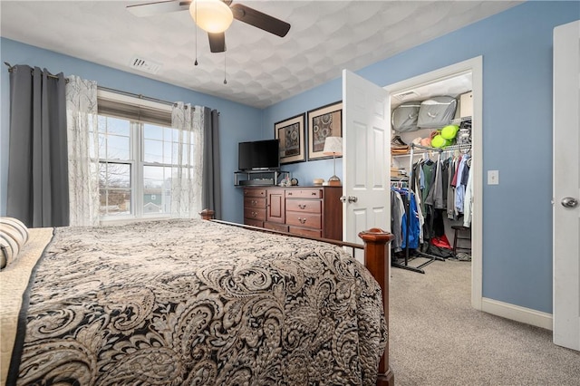 carpeted bedroom featuring a ceiling fan, visible vents, baseboards, a spacious closet, and a closet