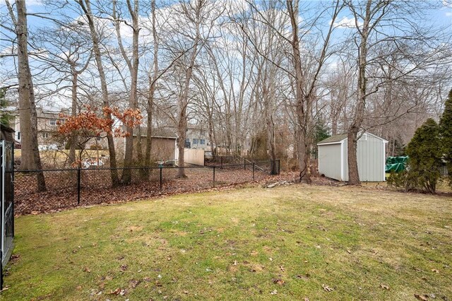 view of yard with an outbuilding, fence, and a storage shed