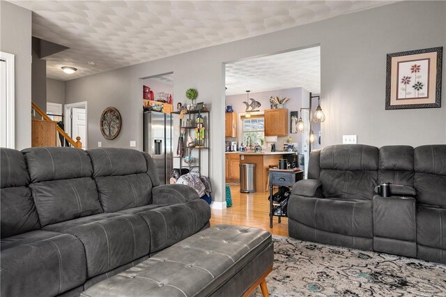 living room featuring stairway and light wood-type flooring